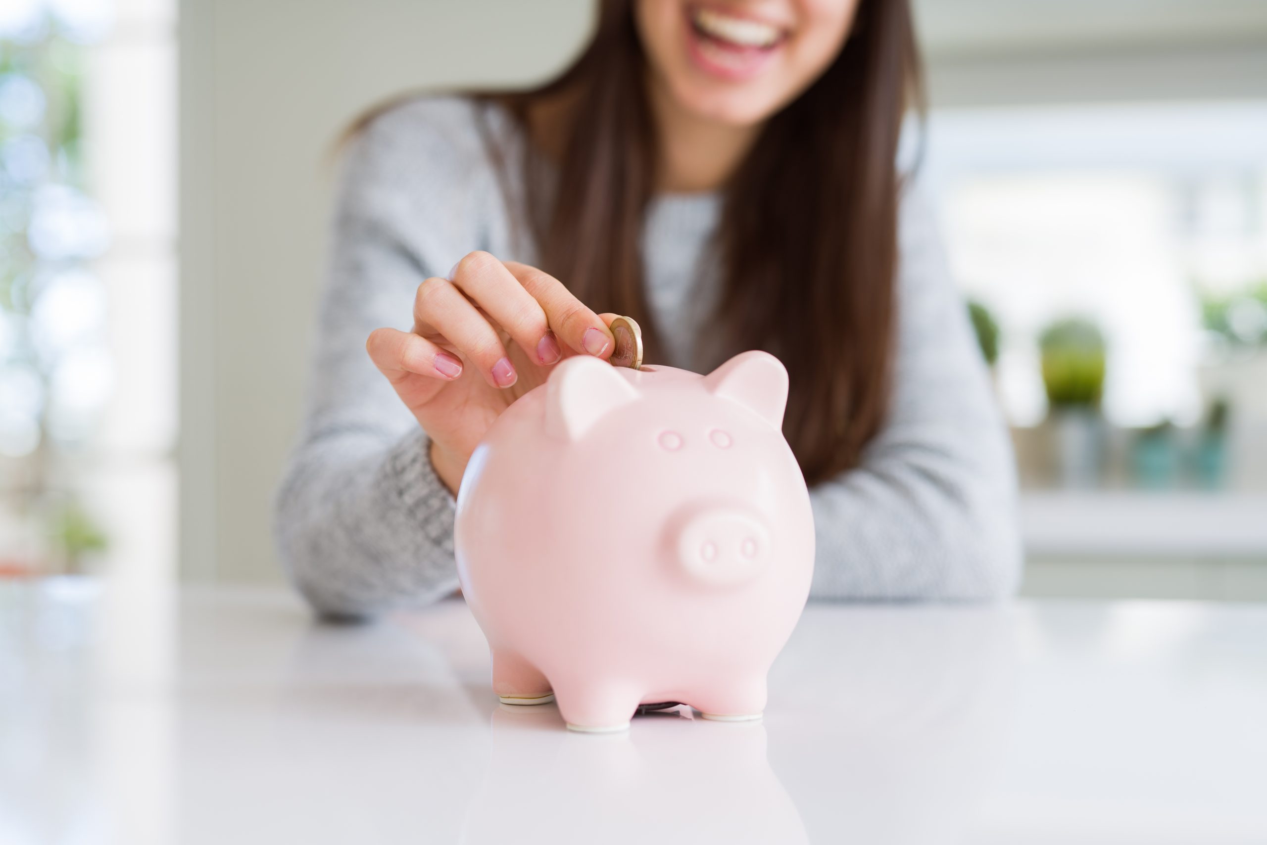 lady put money in piggy bank