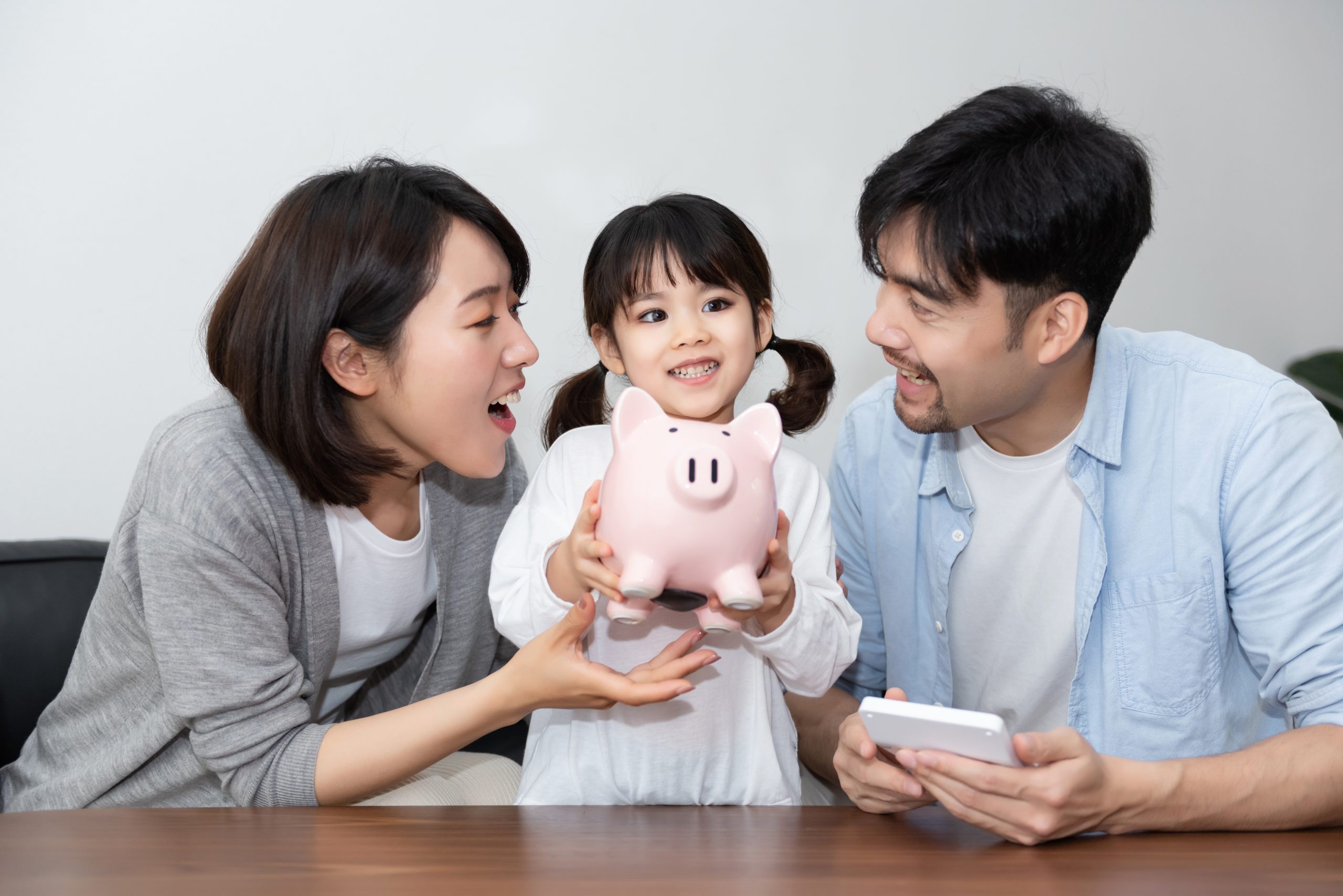 family saving money holding piggy bank topping up cpf