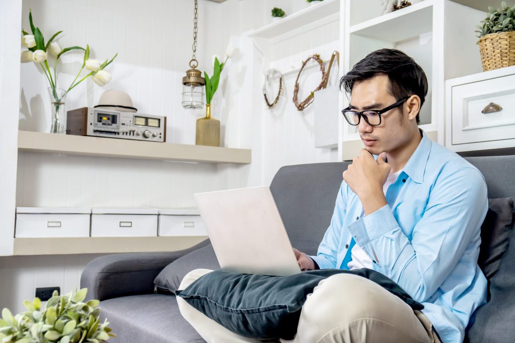 man sitting on the couch looking at insurance policies