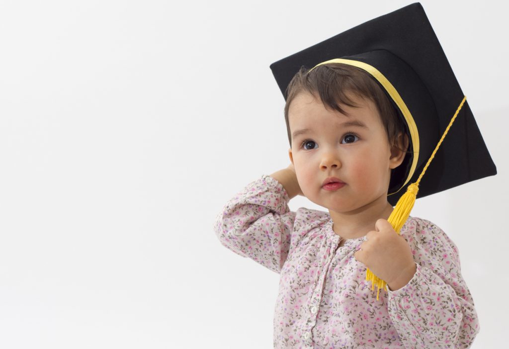 Little girl with graduation hat isolated on white background