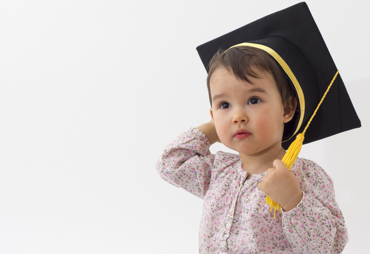 Little girl with graduation hat isolated on white background