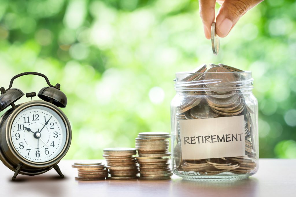 having retirement income, hand putting Coins in glass jar with retro alarm clock for time to money saving for retirement