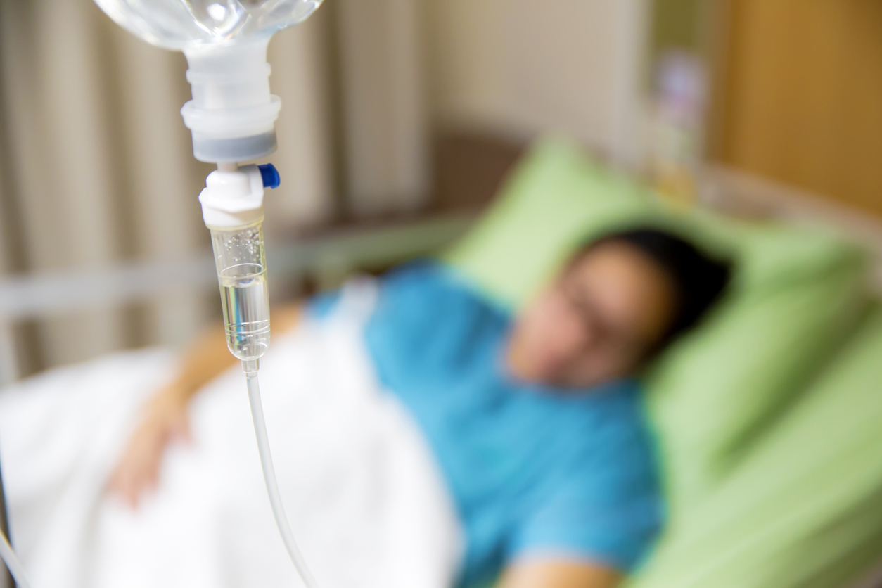 Focus the hanging saline solution with blur patient background.Illness and treatment. Health insurance. Medical Benefits. Reimbursement, Medical expenses. image for illustration, copy space, article.